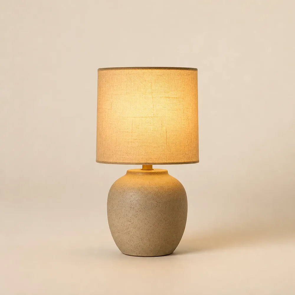 Liten minimalistisk bordslampa med tygskärm och varmt ljus
